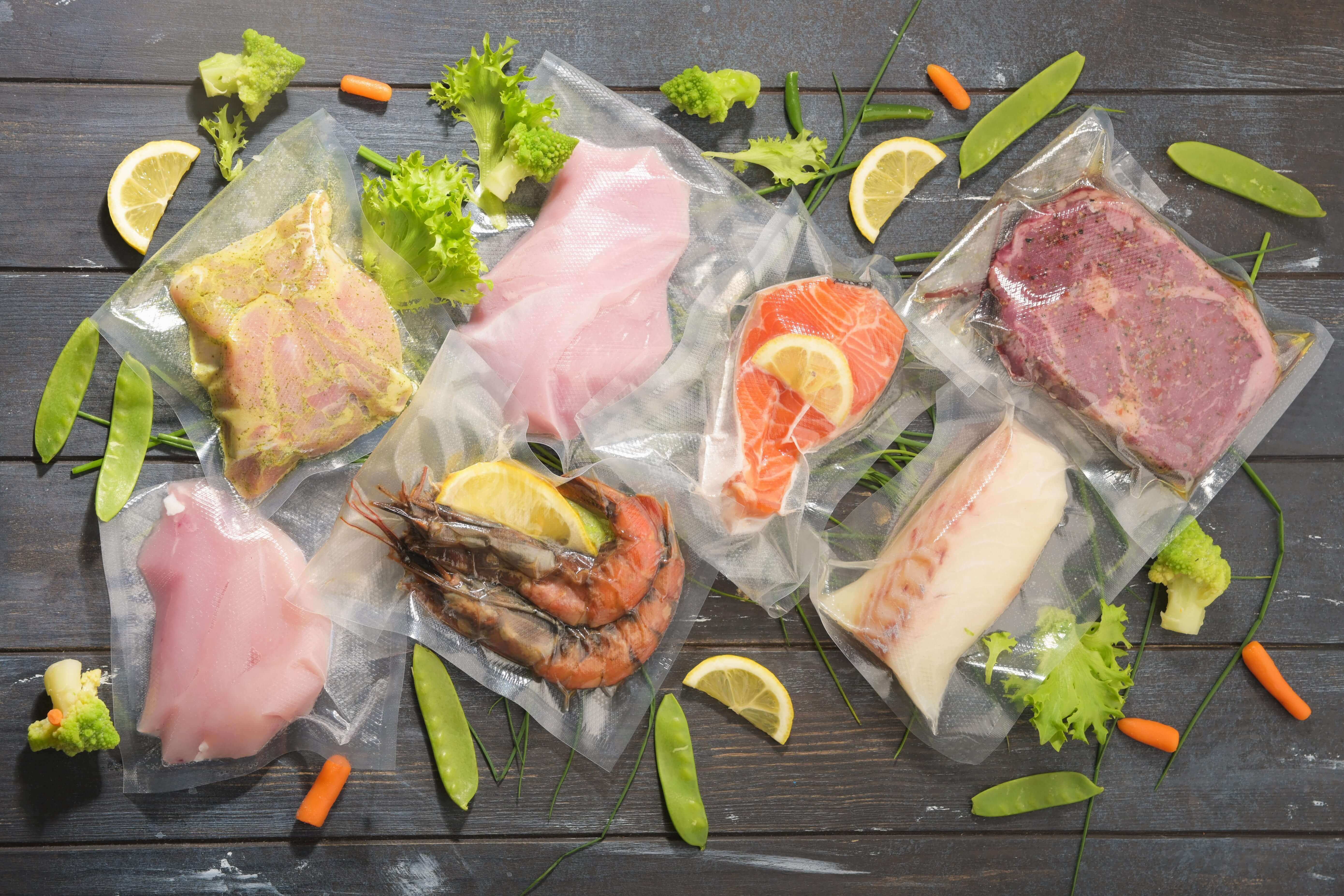 Assortiment de viandes et de fruits de mer sous vide pour une marinade rapide.